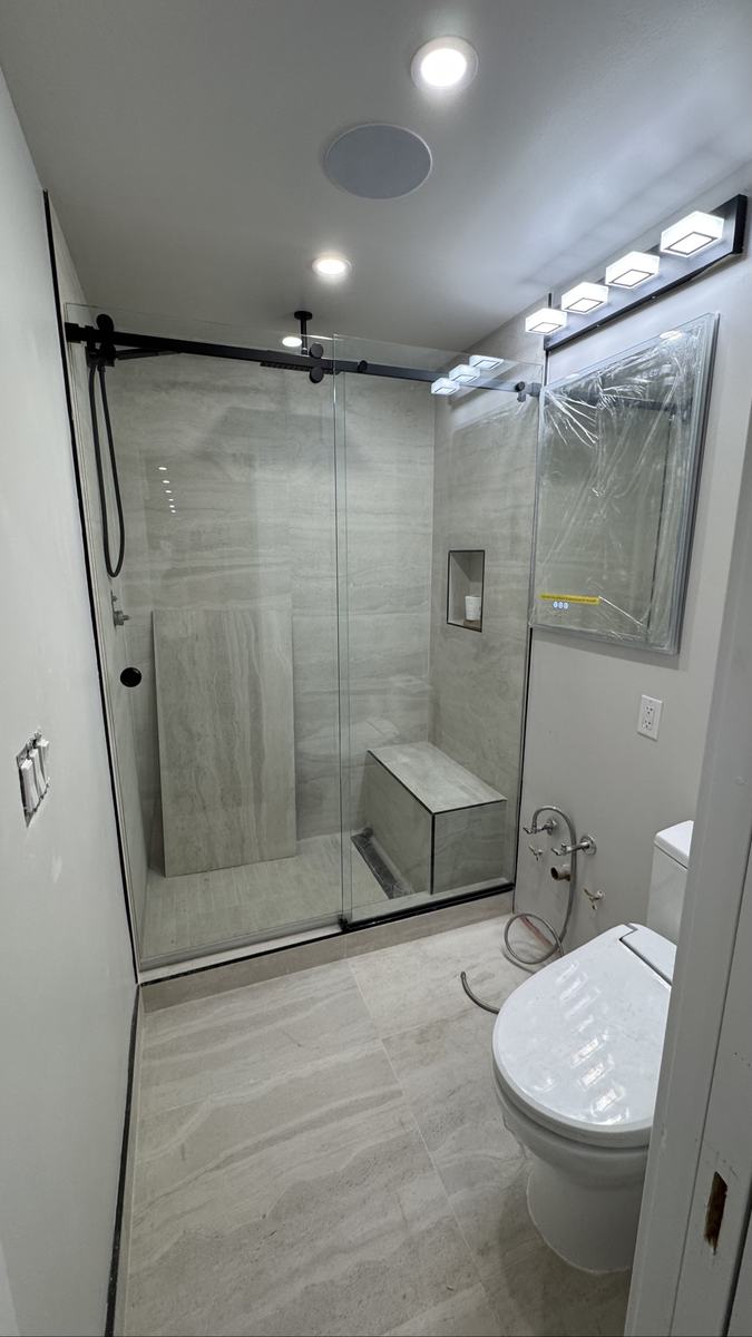 Frameless sliding shower door with matte black hardware